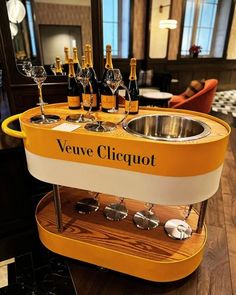 an orange veuve cirquot stand with wine glasses on it