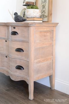 an old dresser with two birds on top