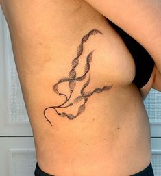 a woman's stomach with a tattoo design on her left side ribcage