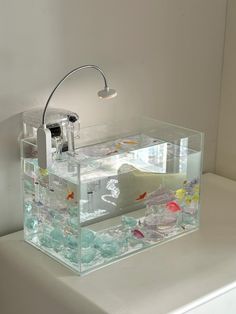 a fish tank is sitting on the edge of a white counter with water in it