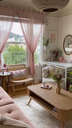 a living room filled with furniture and pink curtains