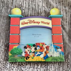 the disney world photo frame has mickey mouse and friends on it