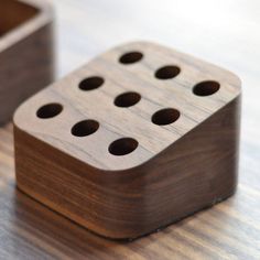 two wooden dices sitting on top of a table next to each other with holes in them