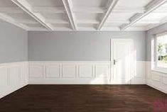 an empty room with white paneling and wood floors