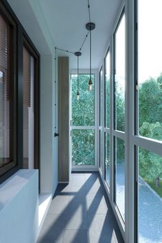 an empty hallway with large windows and lots of light coming in from the outside window