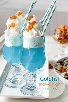 two glasses filled with blue liquid and topped with marshmallows