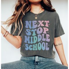 Celebrate your graduate's journey from elementary school to the exciting adventure of middle school with our special graduation shirt. Featuring the bold and empowering message 'Next Stop Middle School,' this shirt is a perfect way to commemorate this important transition in their academic journey. 🎓 Meaningful Design: Our shirt captures the spirit of graduation with its empowering message, symbolizing the exciting next chapter awaiting your graduate as they move on to middle school. 👕 Comfort Casual Letter Print T-shirt For School Events, Relaxed Fit T-shirt With Letter Print For School, Back To School Graphic Tee Shirt With Text Print, Back To School Graphic Tee With Text Print, School T-shirt With Text Print And Relaxed Fit, Back To School Tops With Funny Text, Back To School T-shirt With School Spirit Style, School Spirit T-shirt For Back To School, School Spirit T-shirt Relaxed Fit For Back To School