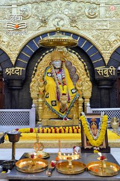 the statue of lord ganesh is surrounded by gold plates and candles in front of it