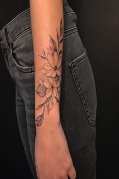 a woman's arm with a flower tattoo on the left side of her arm