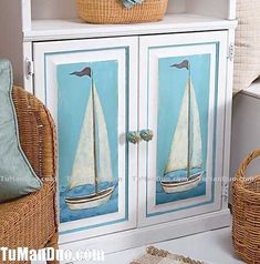 a white cabinet with a sailboat painted on the front and side panels, along with wicker baskets