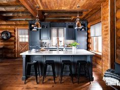 a kitchen with wooden walls and flooring next to an island in the middle of a room