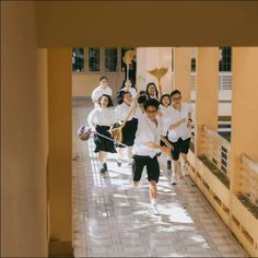 a group of young people walking down a hallway