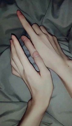 two hands touching each other on a bed