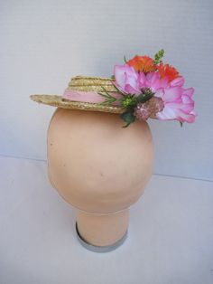 "* A cute mini boater hat has been trimmed out with Easter in mind. Hot pink and vibrant orange flowers complement the carrots off to the side making it a fun and festive hat to wear to any Easter event. * Designed on a 8.0\" diameter round straw hat with an elastic band on the inside. * Designed to look airy and light it would be perfect for a ladies luncheon, charity event or fashion show. * Fun to wear to any Easter Festival or Parade, Egg Hunt, Easter Dinner, Tea or Garden Party, Derby Event Summer Costume Hats With Handmade Flowers, Spring Novelty Hats With Curved Brim, Spring Novelty Hat With Curved Brim, Novelty Curved Brim Hat For Spring, Pink Summer Costume Hats And Headpieces, Fun Pink Costume Hats And Headpieces For Summer, Whimsical Summer Costume Hats With Handmade Flowers, Playful Pink Mini Hat For Summer, Cute Pink Mini Hats For Summer