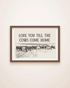 a black and white poster hanging on the wall next to a brown frame with cows in it