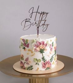 a white and pink birthday cake with flowers on it