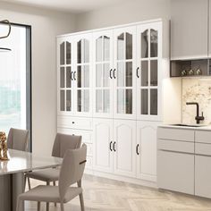 a large kitchen with white cabinets and marble counter tops