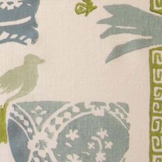 a bird sitting on top of a blue and green pillow cover with white flowers in the background