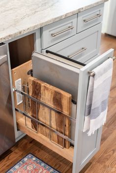 an open drawer in a kitchen next to a dishwasher