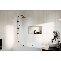 a white bathtub sitting next to a sink in a bathroom under a shower head