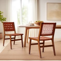 two wooden chairs sitting at a table with a bowl of fruit on top of it