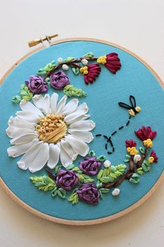 an embroidery project with flowers and butterflies on it