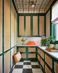 a kitchen with green cabinets and black and white checkerboard flooring on the walls