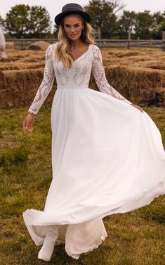 a woman in a long white dress and hat