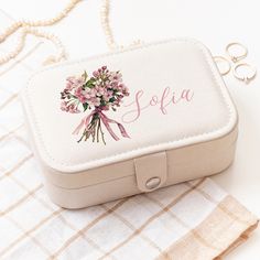 a white box with pink flowers on it sitting on a checkered table cloth next to some scissors