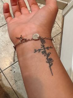 a woman's arm with a tattoo on it and a cross in the middle