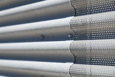 close up view of the side of a building with perforated metal panels on it