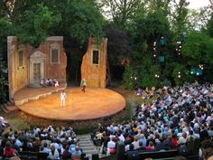 an outdoor theater with people sitting on the stage