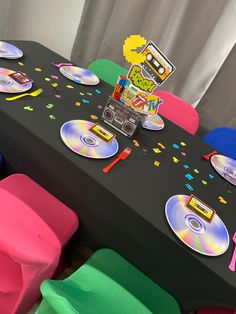 the table is set up with cd's and confetti on it for a party