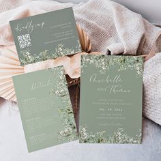 the wedding stationery is laid out on top of a table with flowers and greenery