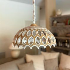 a living room filled with furniture and a light fixture hanging from it's ceiling