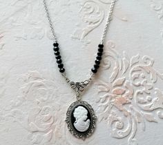 Victorian Romantic Necklace Resin Cameo, Black Beads, Camé Necklace Victorian Necklace, Gothic Chic Necklace Necklace of 41 cm composed of black pearls with facet and a cameo. Scalloped pendant of bronze color measuring 3.50 x 3 cm, the cameo is made of resin. The chain is made of silver-colored stainless steel. The collar is closed by a carabiner clasp plus a 5 cm extension chain, all in stainless steel. Material used: Silver Zinc alloy pendant, and the chain is made of stainless steel Each jewel will be presented to you in a pretty pouch. In order to preserve the shine and lifespan of your jewel or accessory, please do not put them in contact with soap or water, so please remove them. If despite the care taken in the design of your jewel, a defect is noted, do not hesitate to contact me Vintage Black Beaded Necklace For Gift, Black Cameo Necklace As A Gift, Black Cameo Necklace Gift, Black Cameo Necklace For Gift, Gothic Chic, Victorian Necklace, Romantic Necklace, Necklace Resin, Necklace Gothic