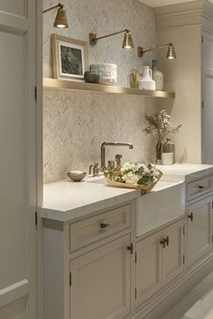 a kitchen with white cabinets and marble counter tops, along with open shelving above the sink