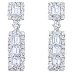 18 kt white gold diamond earrings adorned with baguette cut diamonds surrounded by round diamonds totaling 2.20 cts (HI, VS2-SI1) Luxury Diamond Earrings With Baguette Cut Halo Design, Platinum Diamond Earrings With Baguette Cut For Formal Occasions, Elegant White Diamond Earrings With Baguette Cut, Elegant White Diamond Earrings With Baguette Diamonds, Elegant White Baguette Diamond Earrings, Luxury Platinum Diamond Earrings With Baguette Diamonds, Luxury Platinum Baguette Diamond Earrings, Platinum Diamond Earrings With Baguette Diamonds In White Gold, Platinum Diamond Earrings With Baguette Diamonds For Formal Events