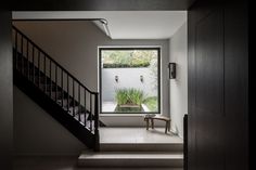 an entryway with stairs leading up to a small window that looks out onto the yard