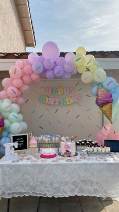 a birthday party with balloons, cake and cupcakes