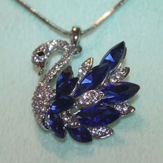 Nwt: Beautiful Swan Necklace With Blue & Clear Rhinestones, It Also Has Clear Crystals On His Head & Neck. 18" Silver Plated Chain, 1 3/4" High Swan Blue Crystal Jewelry With Rhinestones, Blue Necklaces With Sparkling Stones For Anniversary, Elegant Blue Rhinestone Necklace Gift, Blue Crystal Necklaces With Bling, Blue Crystal Necklaces With Diamond Accents, Blue Crystal Jewelry With Bling, Blue Crystal Necklace With Diamond Accents, Blue Rhinestone Jewelry For Gifts, Elegant Blue Rhinestone Necklace With Sparkling Stones