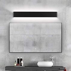 a bathroom with a sink, mirror and towel dispenser on the wall