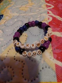 two beaded bracelets sitting on top of a colorful tablecloth covered table cloth