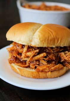 a pulled pork sandwich on a white plate