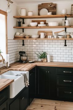 the kitchen is clean and ready to be used for cooking or baking, with dishes on shelves above the sink