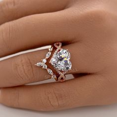 a woman's hand with a diamond ring on top of her finger and an engagement band