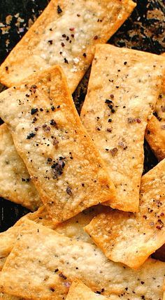 some crackers that are sitting on top of a black plate with sprinkles