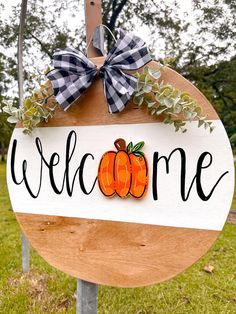 a welcome sign hanging on the side of a wooden pole