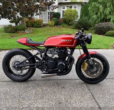 a red motorcycle parked in front of a house