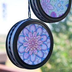 two circular stained glass ornaments hanging from a window